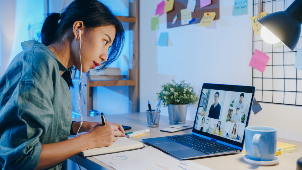 A woman on a video call, working on a laptop at home
